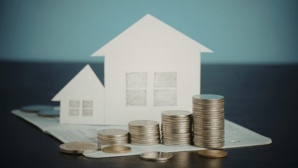 paper house with coin stacks